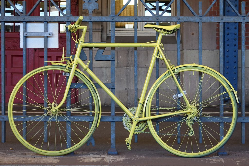 Image of a yellow bike outside of a French train station.